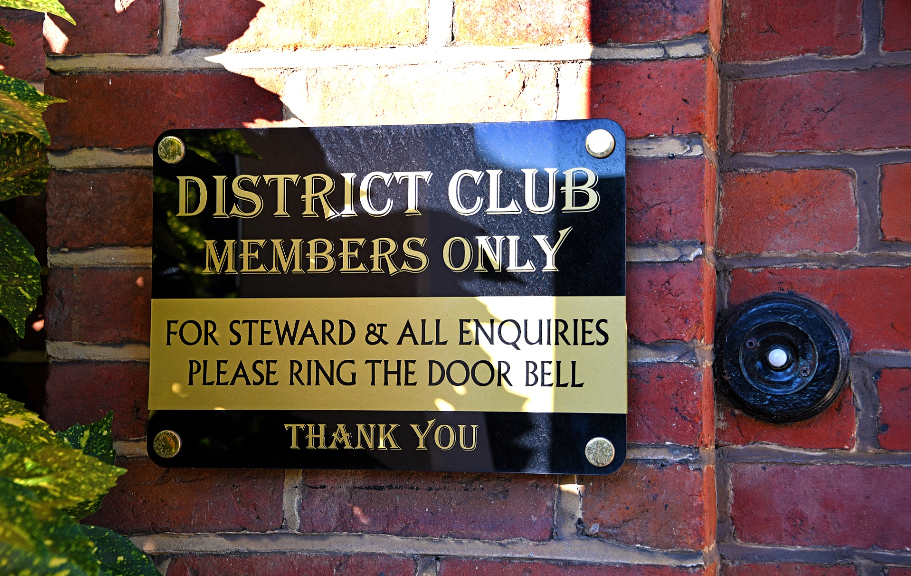 A brass plaque on the club door - Members Only - beside the door bell.